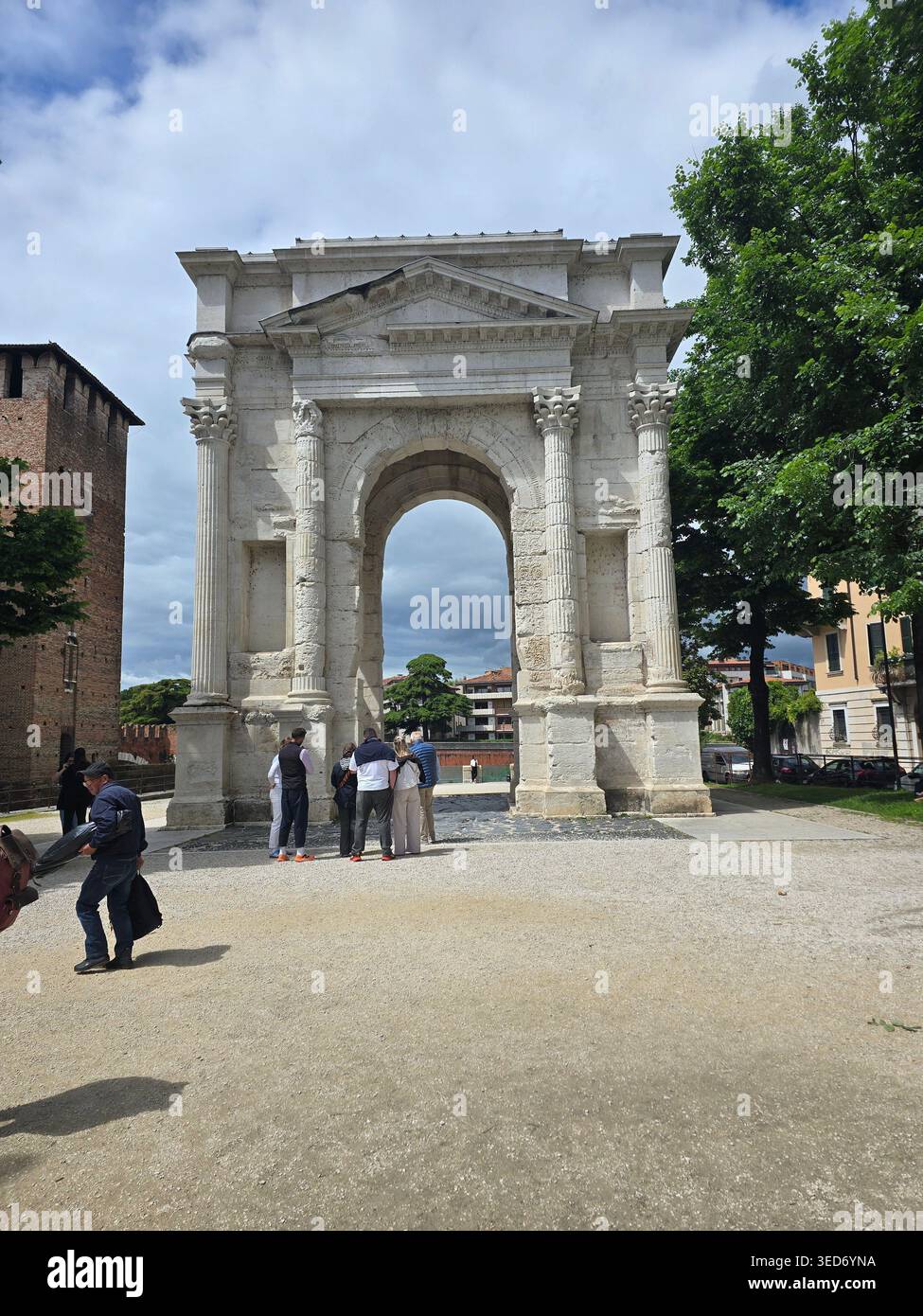 Der antike römische Arco dei Gavi Triumphbogen mit Touristen an seiner Basis in Verona, Veneto, Italien - Smartphone-aufgenommenes Stockfoto