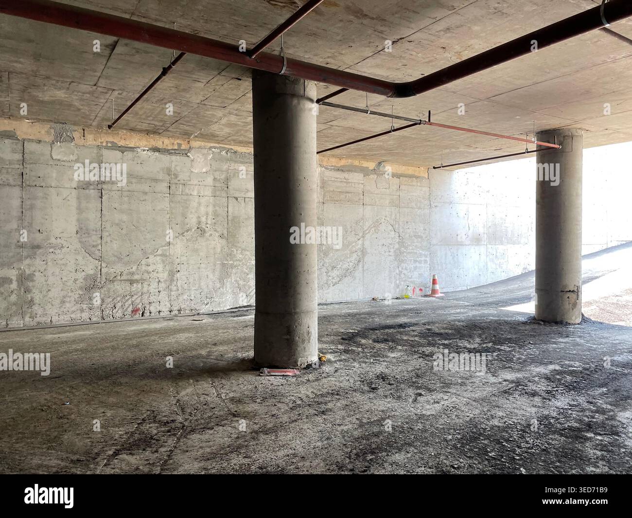 Innenraum aus Rohbeton mit Säulen und offenem Raum in unvollendeter Parkgarage Stockfoto