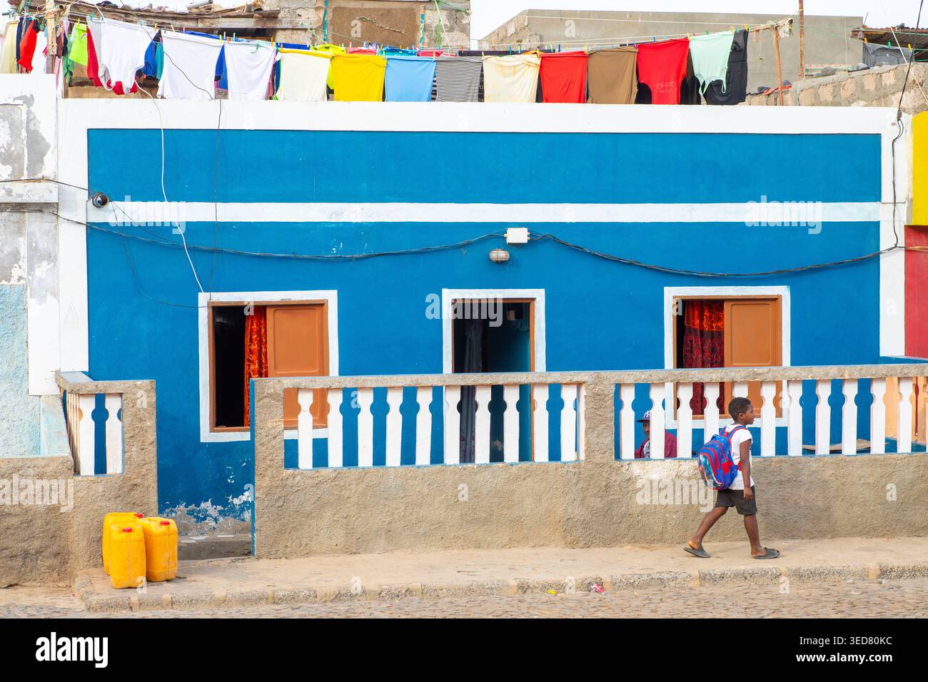 Kap Verde, São Vicente, Salamansa, Schuljunge vor einem farbenfrohen Haus, in dem Wäsche trocknet Stockfoto
