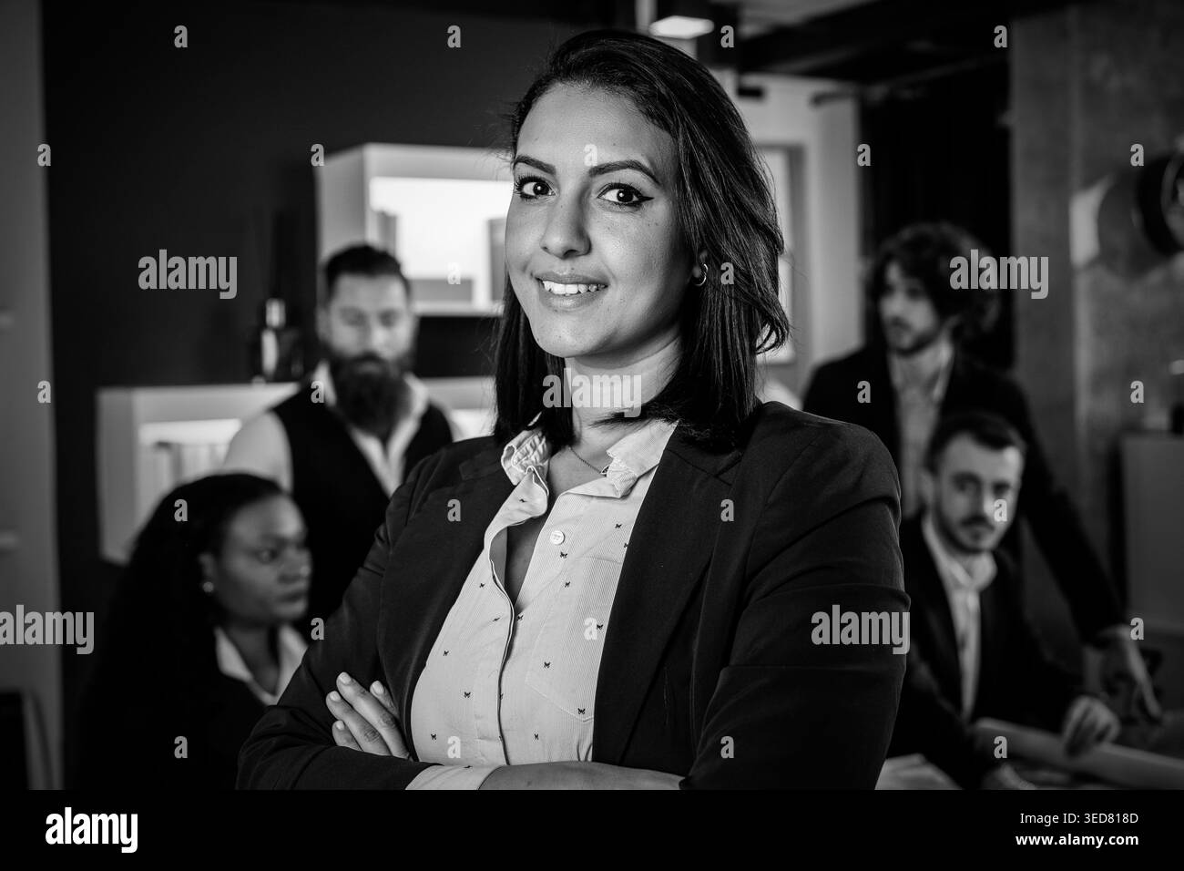 nordafrikanische Geschäftsfrau, die in einem modernen Büro arbeitet, mit dem multiethnischen Team hinter ihr – Konzept der Führung und Teamarbeit, die Ziele erreicht – F Stockfoto