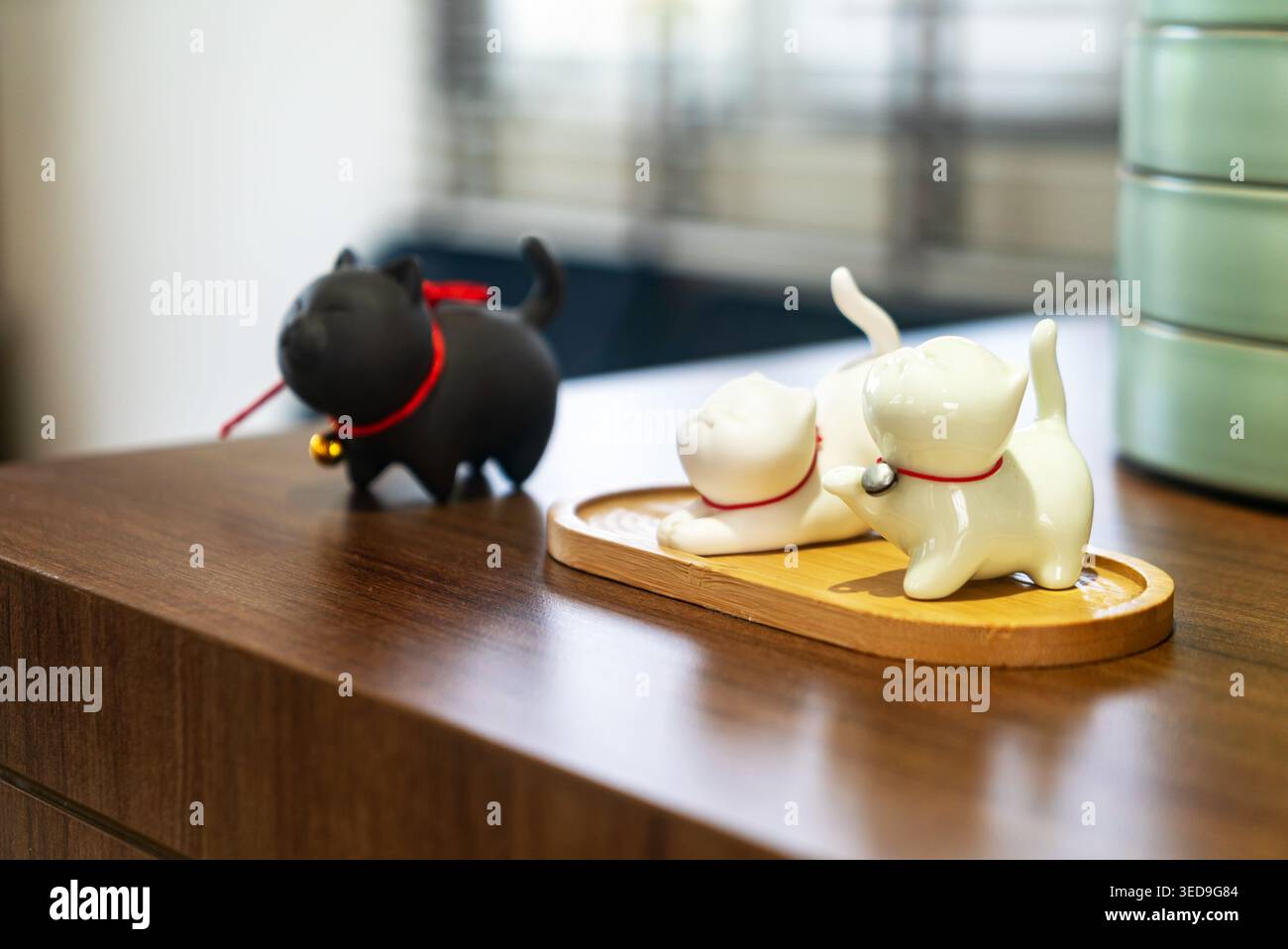 Dekorative Keramikfiguren einer Katze und eines Hundes auf einer Holzoberfläche verleihen Innenräumen einen charmanten und verspielten Touch, perfekt für die Inneneinrichtung Stockfoto