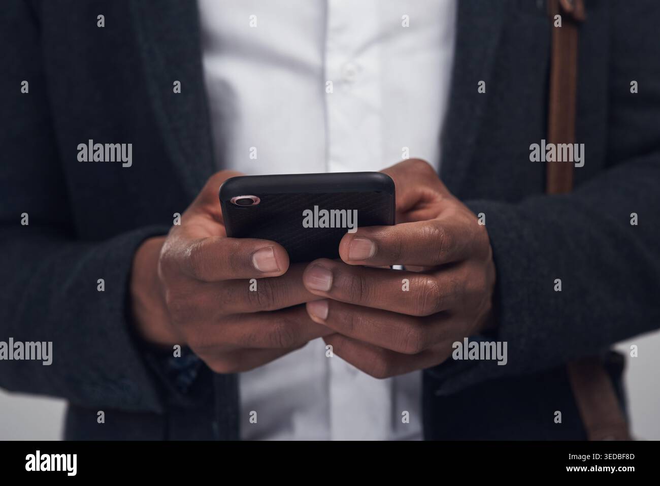 Hände, Telefon und Tippen mit Geschäftsmann im Studio für Kommunikation, Vernetzung oder Suche. App, soziale Medien und Textnachrichten für Mitarbeiter bei der Arbeit Stockfoto