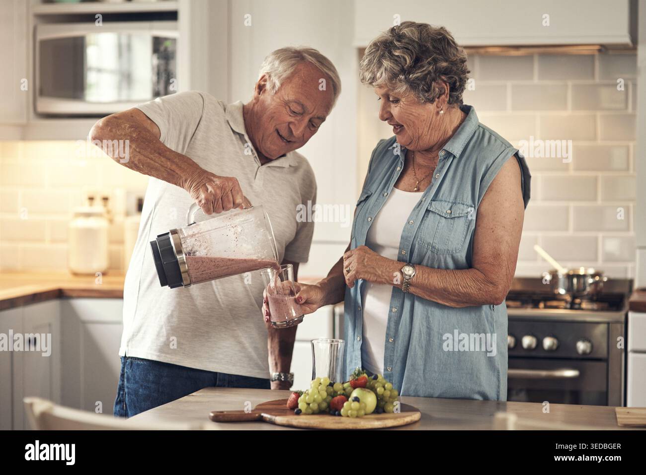 Mixer, glückliches und Senior Paar in der Küche mit Smoothie für Ernährung, Gesundheit oder Diät Frühstück. Mixer, Zutaten und ältere Menschen mit Flüssigkeit Stockfoto