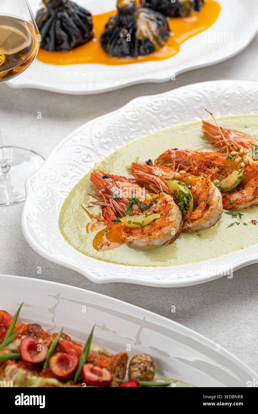 Gegrillte Garnelen mit Kräutern und Sauce auf Teller Stockfoto