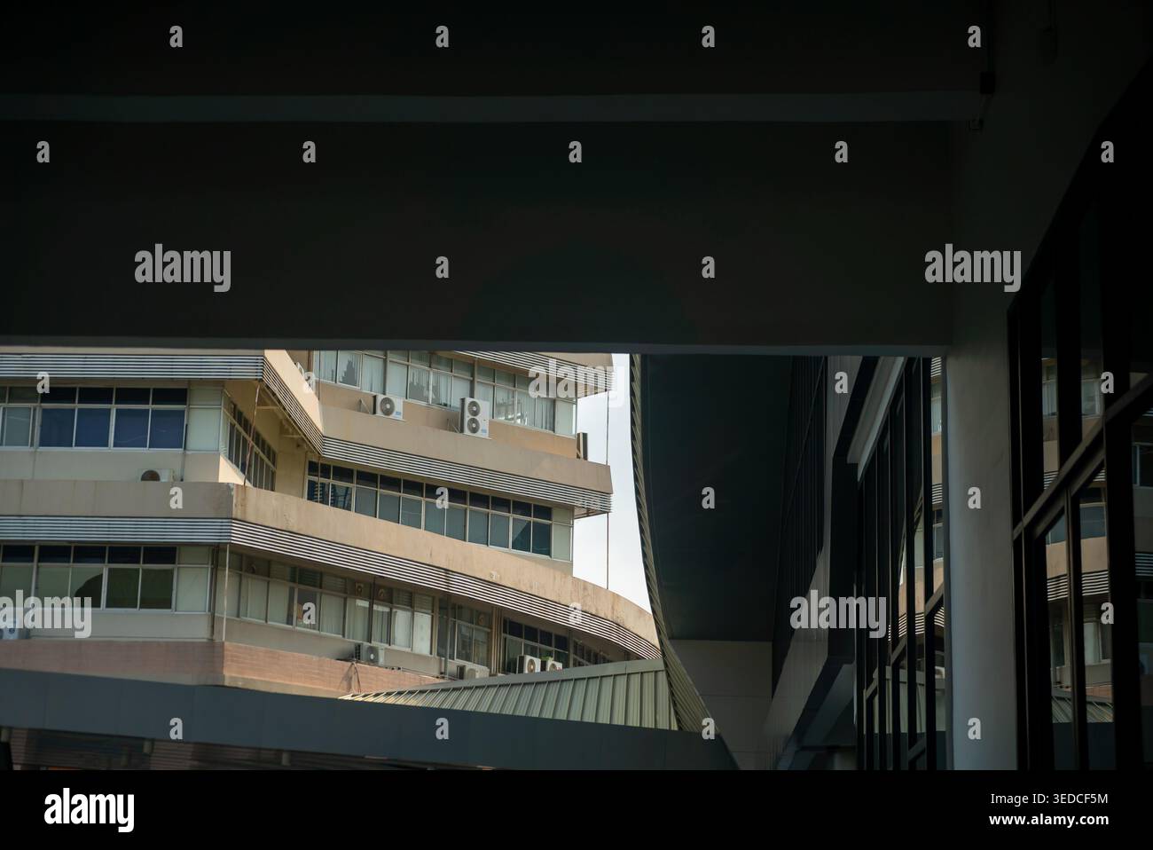 Fesselnder Blick auf eine moderne städtische Architektur mit einzigartigen Winkeln und Geometrie, mit einer Mischung aus Glas- und Betonelementen. Stockfoto