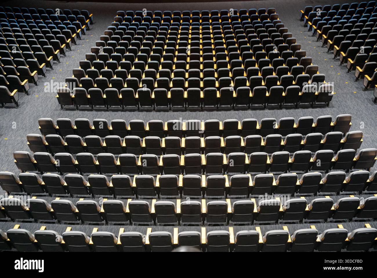 Aus der Vogelperspektive eines leeren Theaters mit Sitzreihen, die symmetrisch angeordnet sind und das moderne Design und die architektonischen Elemente o hervorheben Stockfoto