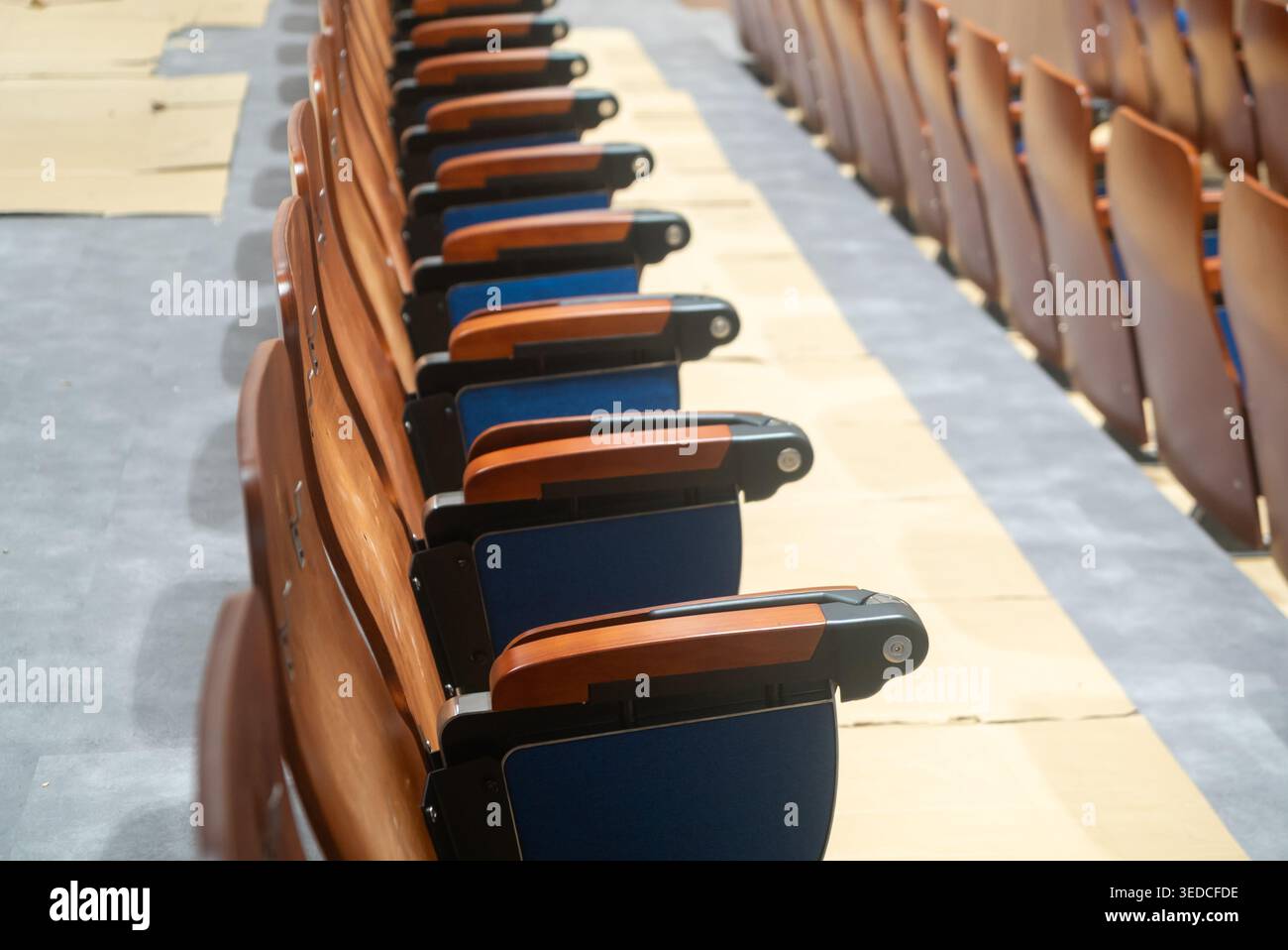 Eine Reihe von leeren Konferenzstühlen in ordentlichen Reihen mit modernem Design und Holzelementen, perfekt für die Veranstaltungsplanung und Tagungen Stockfoto