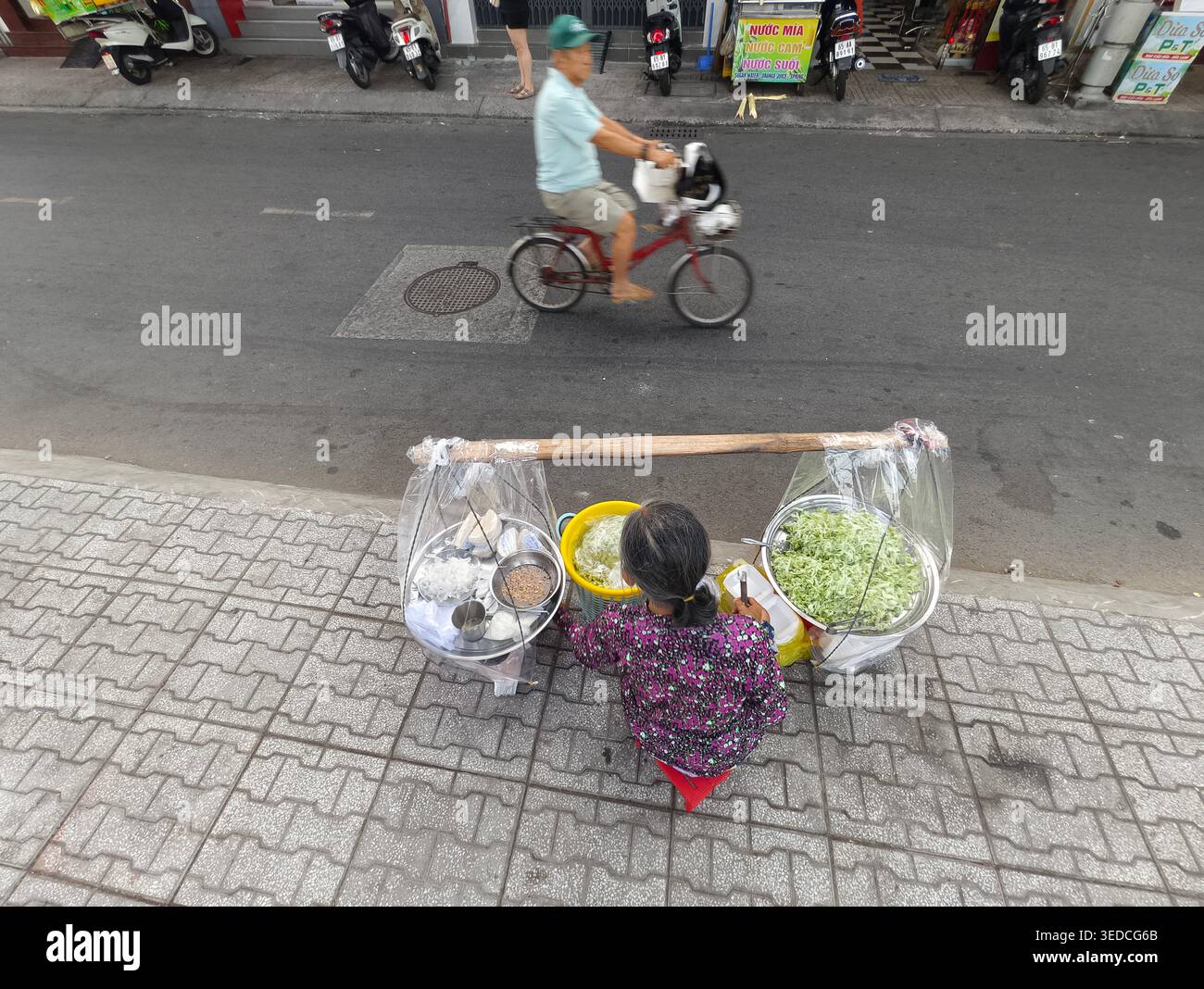 Straßenverkäufer, zubereitet oder verkauft lokale gỏi khô bò (getrockneter Rindfleischsalat), frische Gerichte von einem mobilen Setup auf einem Bürgersteig, Can Tho, Vietnam Stockfoto