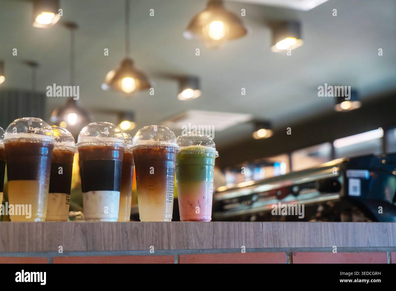Eine lebendige Auswahl an Eisgetränken mit verschiedenen Geschmacksrichtungen und Farben in einem modernen Café. Ideal, um die Essenz von lässiger Re festzuhalten Stockfoto