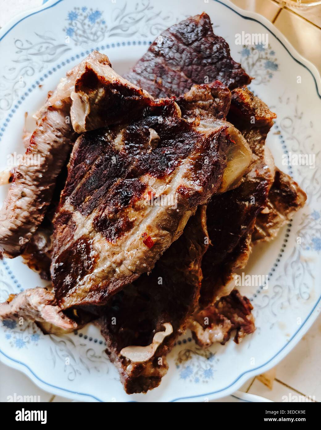 Geröstete Fleischscheiben auf Keramikplatte in warmem natürlichem Licht serviert. Rustikales hausgemachtes Dinner-Konzept für Proteinmahlzeit, traditionelle Küche und herzhafte Speisen Stockfoto