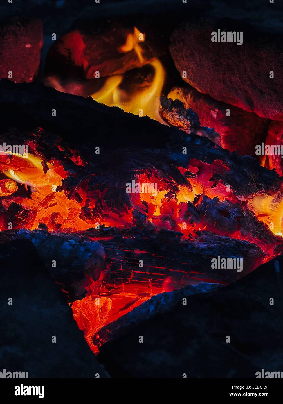 Glühendes Brennholz brennt mit leuchtenden orangen Flammen im Detail. Warmes Wärmekonzept für Kamin, Winterkomfort, Energie und natürliche Feuerstruktur. Stockfoto