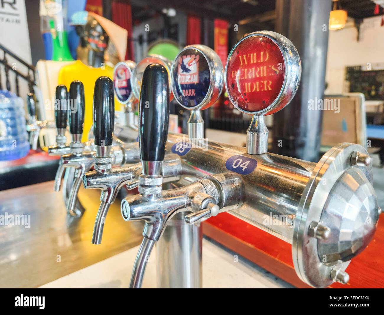 chrom-Bar-Bierzapfen mit schwarzen Griffen an einer Bar, Waldbeeren Cidre-Schild Stockfoto