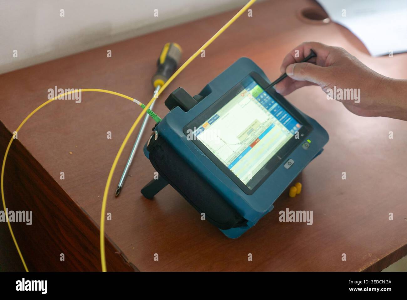 Ein Techniker interagiert mit einem modernen Testgerät in einem gut ausgestatteten Arbeitsbereich und bietet fortschrittliche Technologie für präzise Messungen und Analysen Stockfoto