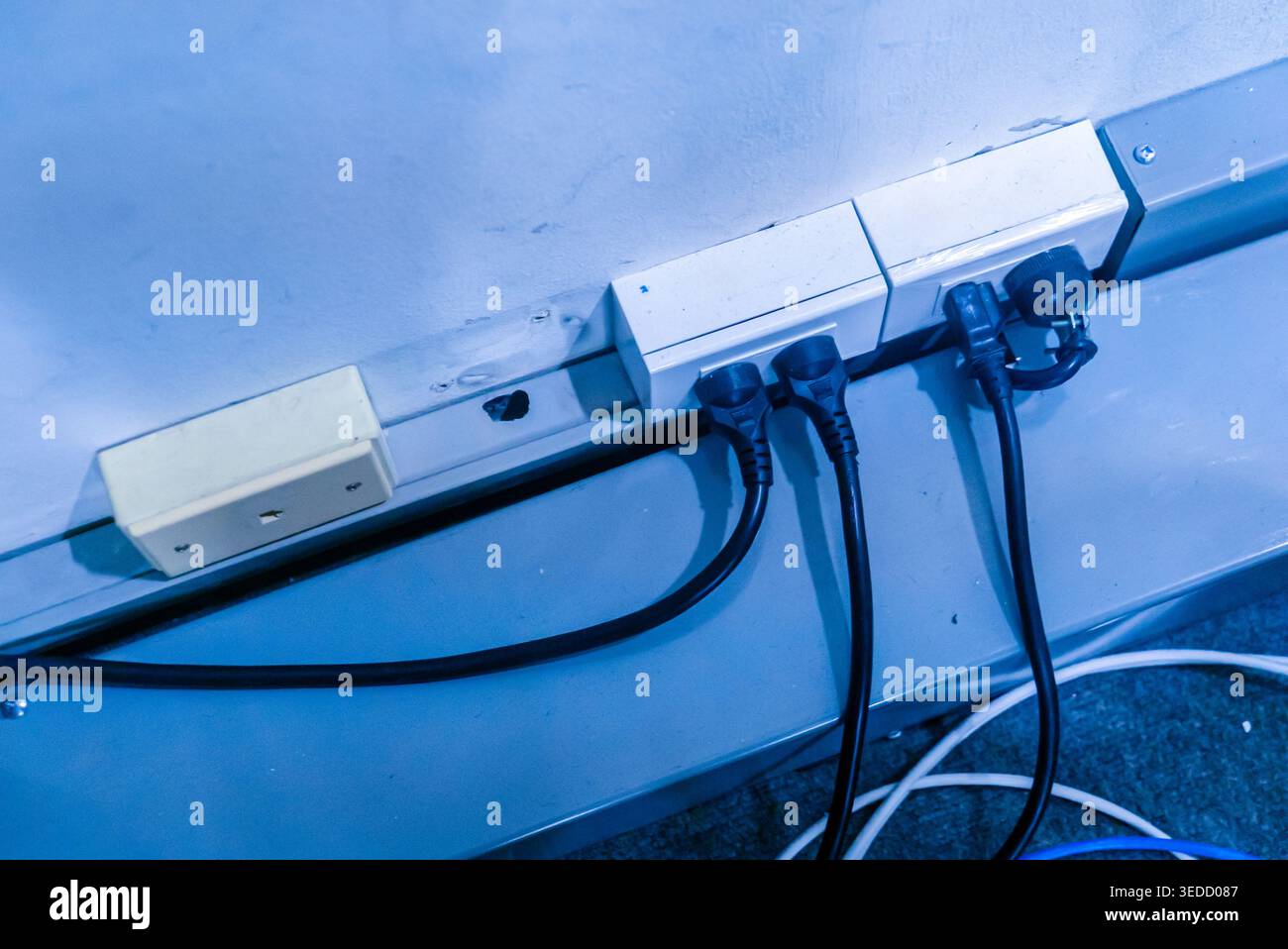 Abbildung einer Steckdosenleiste mit mehreren Kabeln, die elektrische Verkabelung in einer modernen Innenumgebung zeigt. Ideal für Technologie und Versorgungsunternehmen Stockfoto