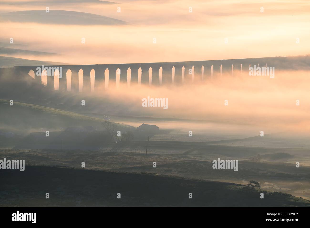 Ribblehead Viaduct mit wunderschönem Morgensonnenlicht, das durch den Nebel und Nebel im Yorkshire Dales National Park, Großbritannien, bricht. Stockfoto