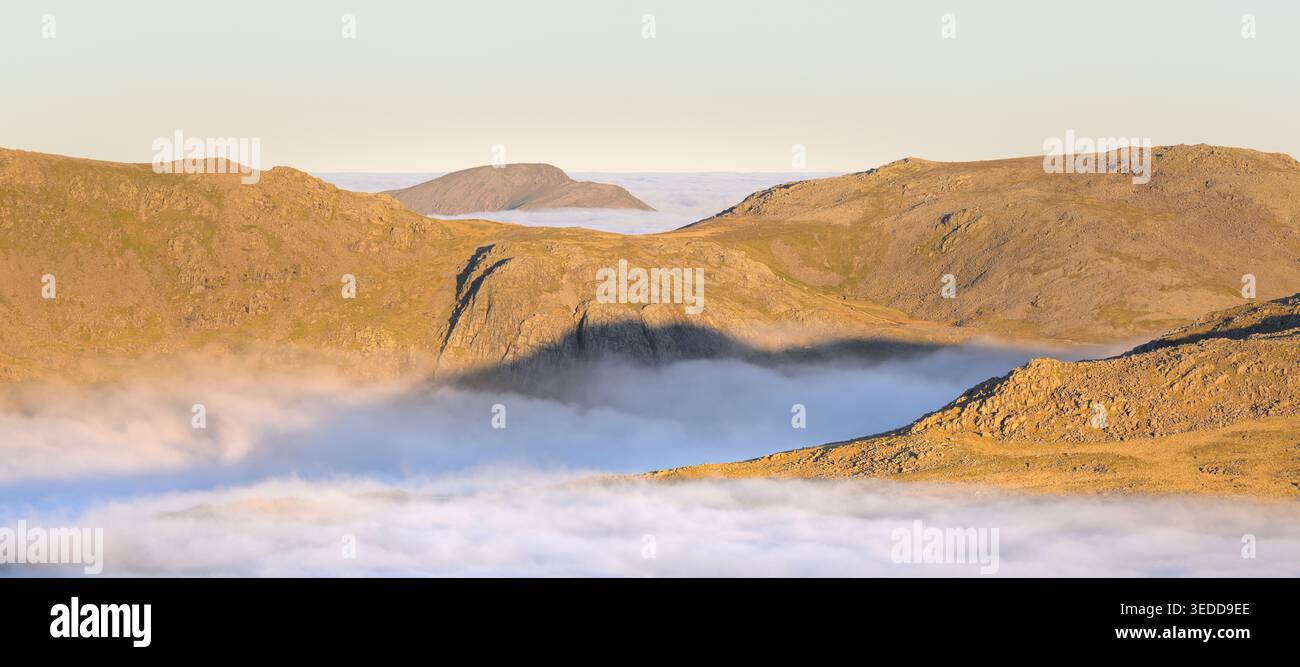 Morgenlicht auf den Bergen des Lake District mit Wolkenumkehr und Blick über Great End und Pillar. Cumbria, England. Stockfoto