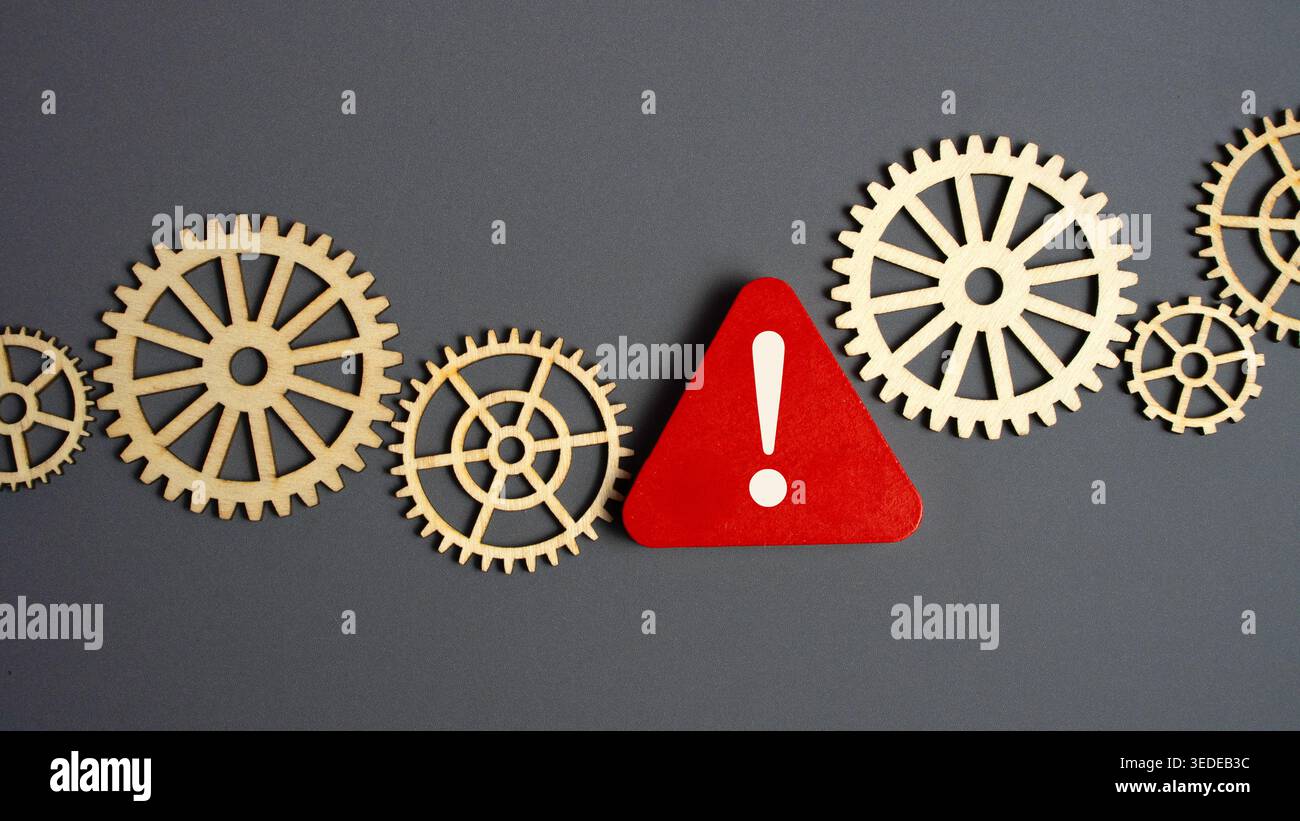 Rotes Warnschild zwischen hölzernen Zahnrädern, das das Konzept des industriellen Risikos und des mechanischen Systemausfalls darstellt Stockfoto