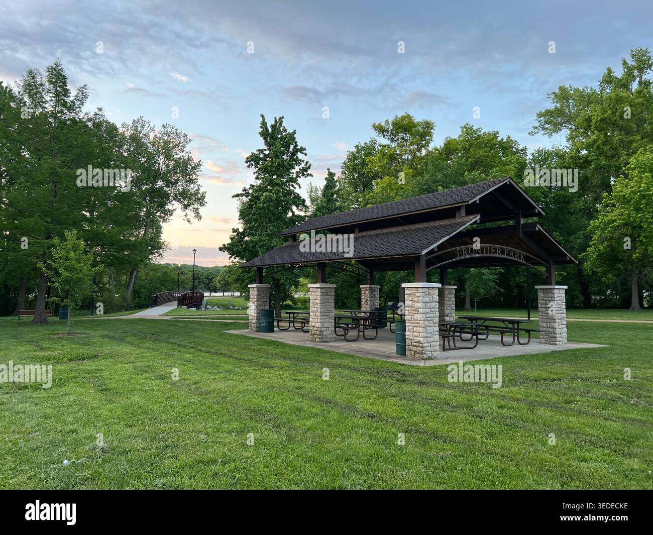 Pavillon und Picknickbereich im Frontier Park in St. Charles, Missouri, USA, öffentlicher Park am Fluss mit Brücke und Abendhimmel Stockfoto