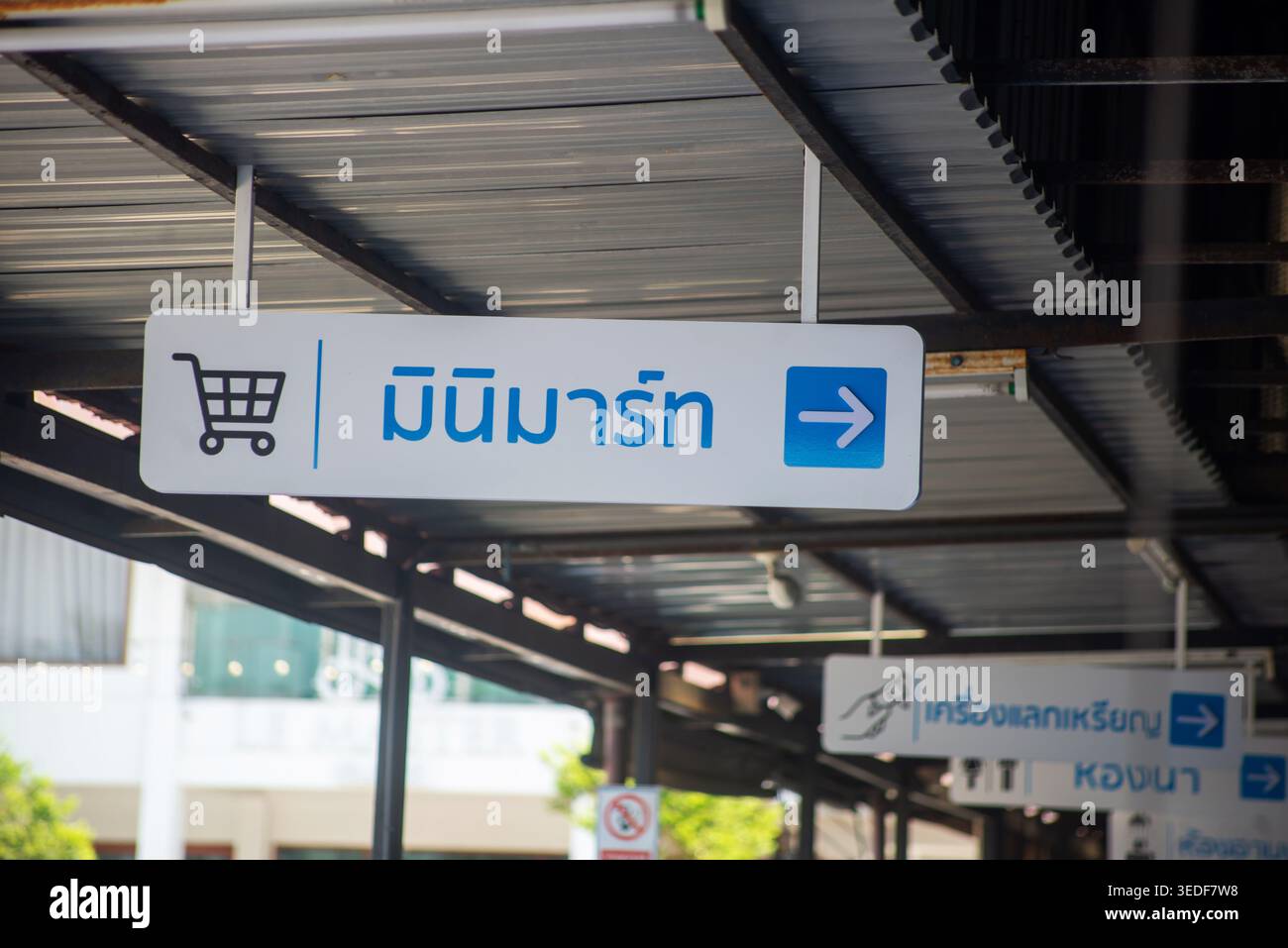 Ein klares Shopping-Schild in thailändischer Sprache, das die Käufer auf einen lokalen Markt hinweist. Das Bild fängt das Wesen des urbanen Handels und der kulturellen Beschilderung ein. Stockfoto
