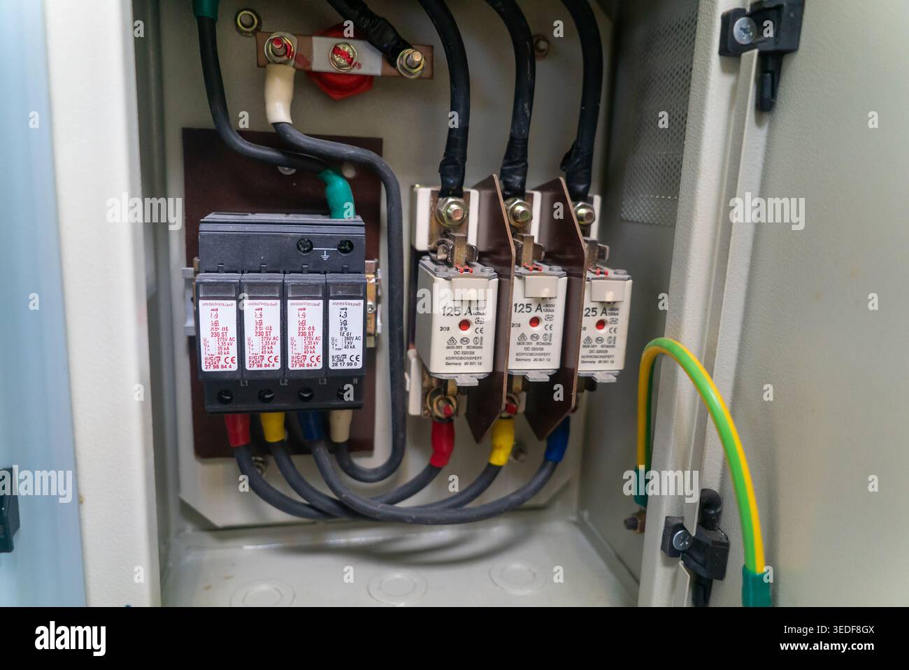 Nahaufnahme einer Leistungsschaltertafel mit verschiedenen elektrischen Komponenten und Kabelanschlüssen, die für das Energiemanagement und die Sicherheit in unerlässlich sind Stockfoto