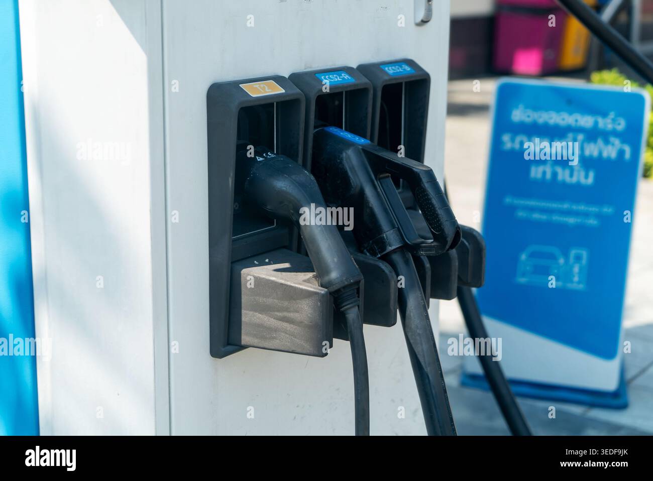 Nahaufnahme einer Ladestation für Elektrofahrzeuge mit Steckverbindern und Netzsteckern, die zum Aufladen von Elektroautos erforderlich sind. Ideal für Techno Stockfoto