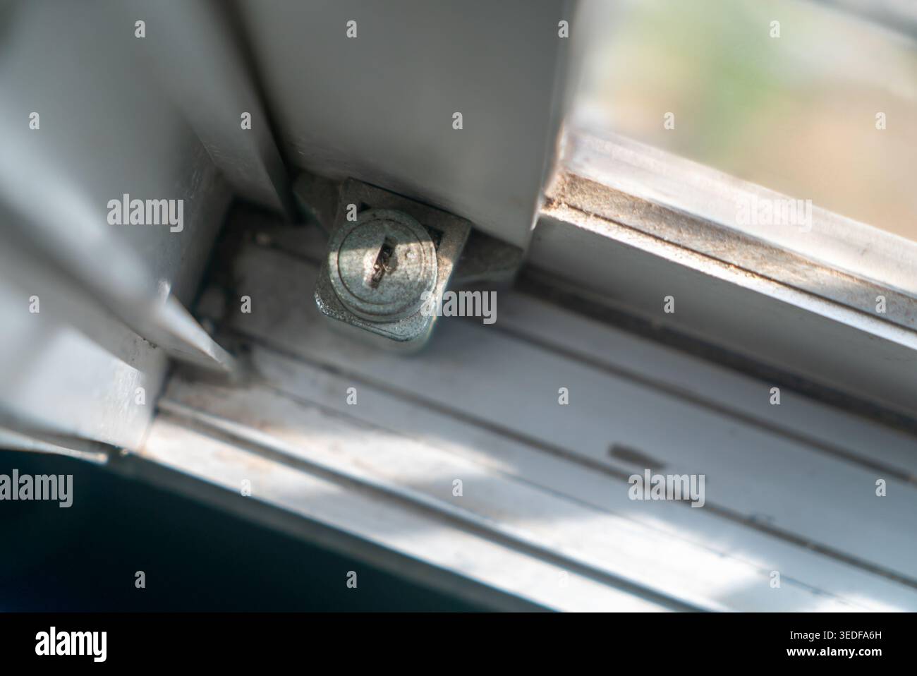 Eine detaillierte Nahaufnahme eines metallischen Verriegelungsmechanismus für Fenster. Dieses Bild zeigt die komplizierte Hardware, die Sicherheit und Funktionalität gewährleistet Stockfoto