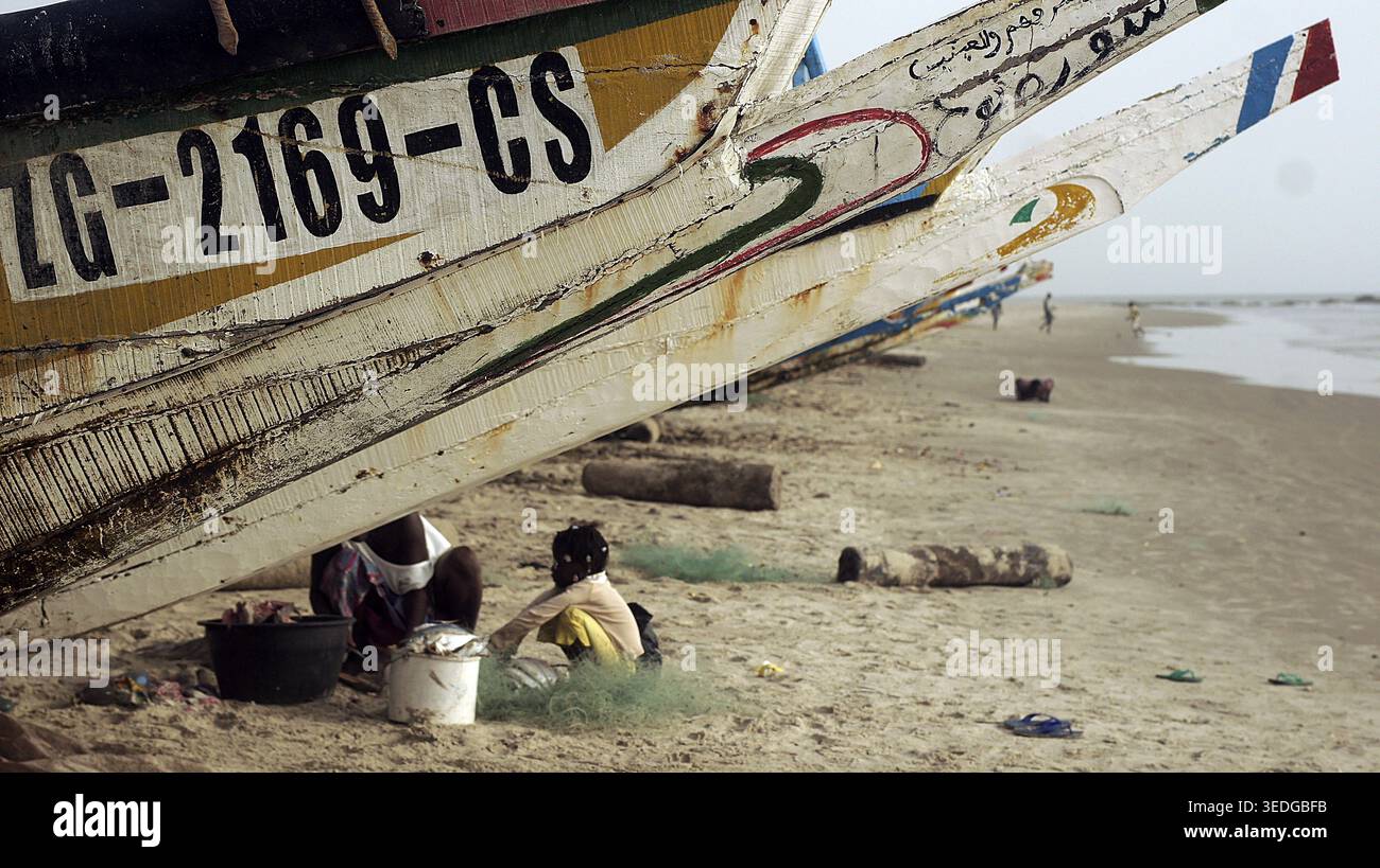 Fischerboote mit Leuten, die an einem sonnigen Tag arbeiten, Cap Skirring, Casamance, Senegal Stockfoto