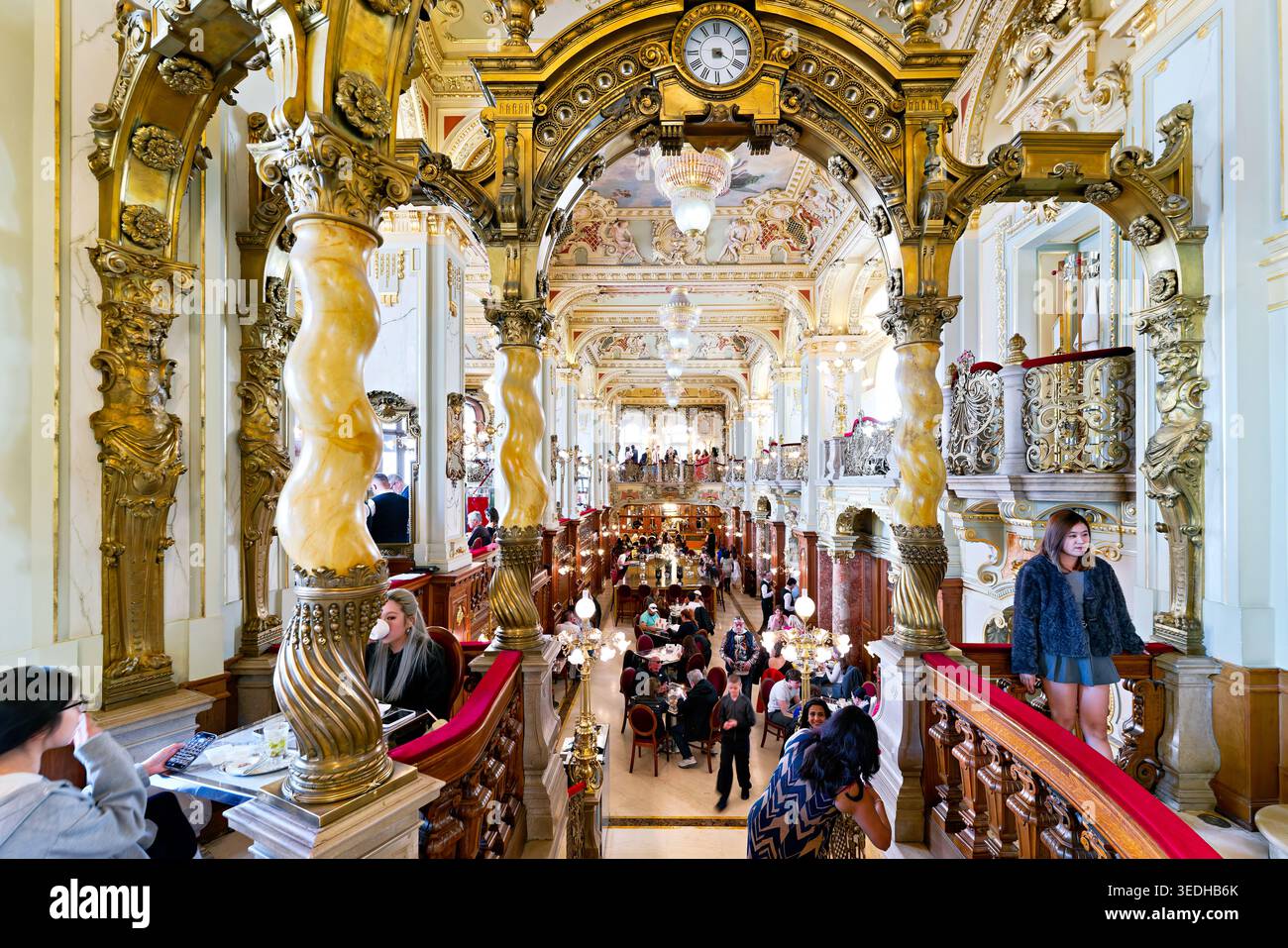 Die Leute genießen Getränke und Mahlzeiten im New York Cafe in Budapest. Das Café hat ein kunstvolles Dekor und eine lebhafte Atmosphäre mit vielen Besuchern. Stockfoto