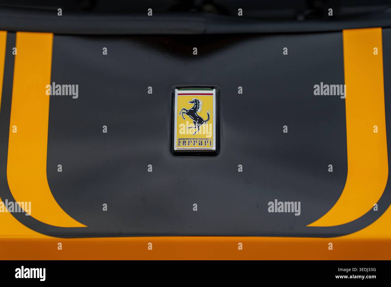 Nahaufnahme des Ferrari-Emblems auf einer gelb-schwarzen Motorhaube für Supersportwagen, dem legendären Luxuslogo für Automobile und Außendetails für Sportwagen Stockfoto