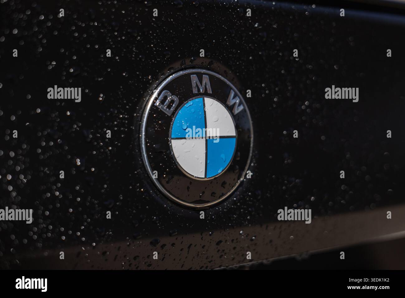 Slowenien, Ljubljana - 8. April 2026: BMW-Logo auf dunkler Oberfläche mit Wassertropfen. Stockfoto