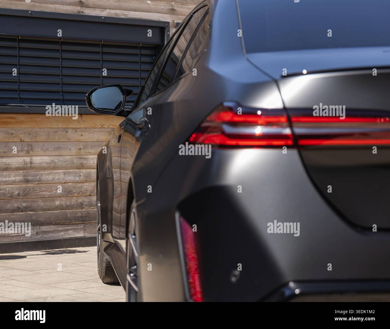 Slowenien, Ljubljana - 8. April 2026: Der BMW M5 steht vor einer Holzwand mit Tageslicht Stockfoto