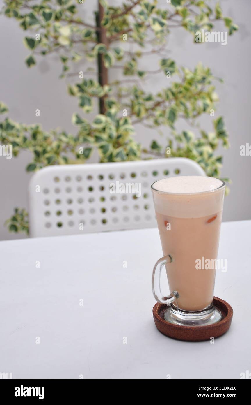 Im kopitiam-Stil geeiste tarik serviert in einem hohen Glas auf einem weißen Tisch Stockfoto