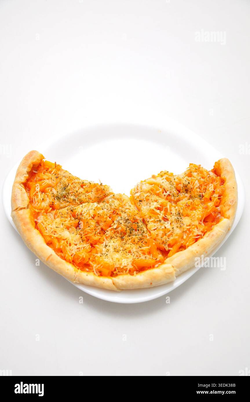 Handgemachte Pizza in Pfannenform mit Tomatensauce, Fleisch- und Käsebelag, serviert auf einem Teller auf einem weißen Tisch Stockfoto