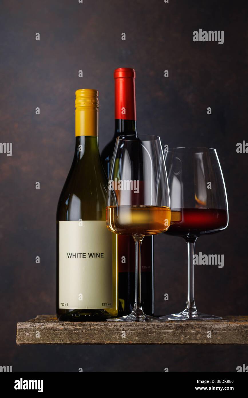 Gläser Rot- und Weißwein mit Flaschen auf dunklem Hintergrund Stockfoto