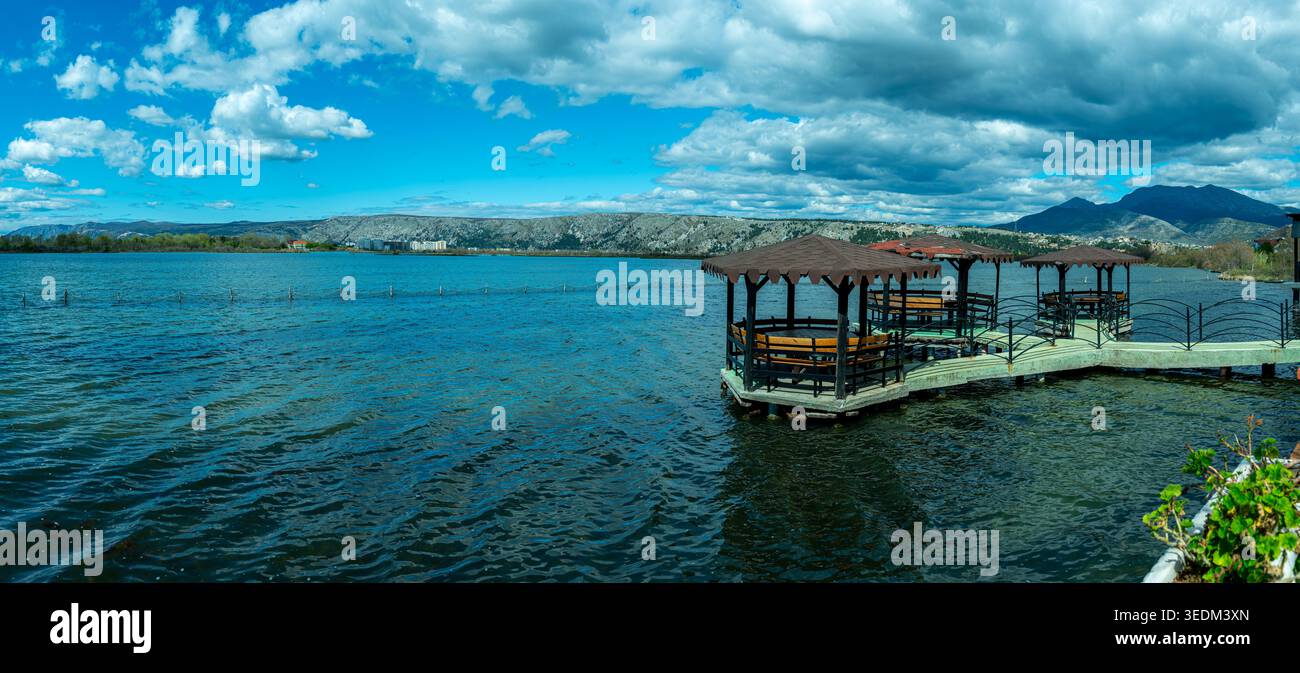 Hölzerne Pavillons und Picknickbereiche befinden sich auf einem Pier über dem Wasser in Ishull Lezhë, Albanien, und bieten einen ruhigen Ort zum Entspannen am See. Stockfoto