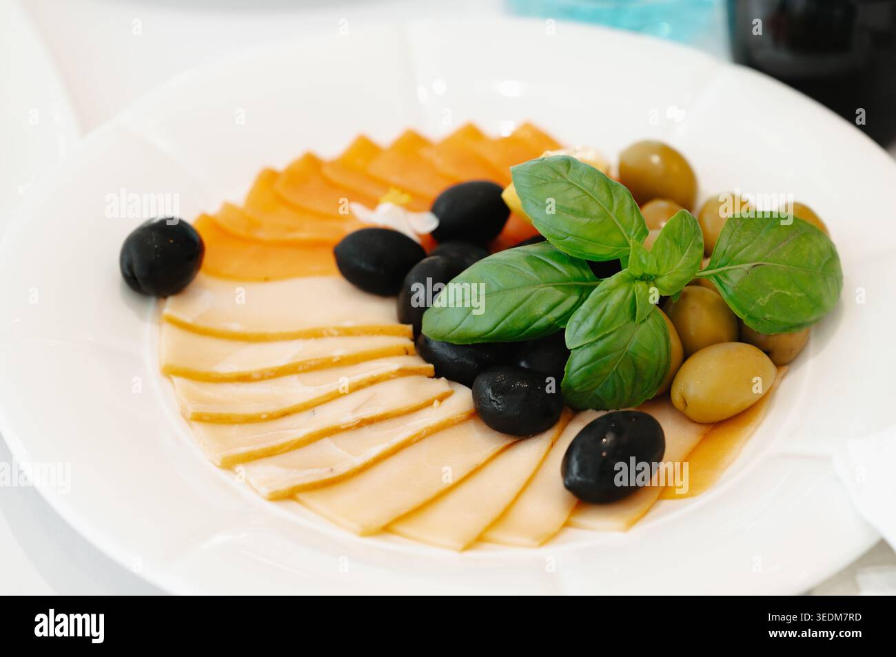 Mediterrane Vorspeise Mit Käseoliven. Käsescheiben Gepaart Mit Oliven Und Frischen Kräutern Stockfoto