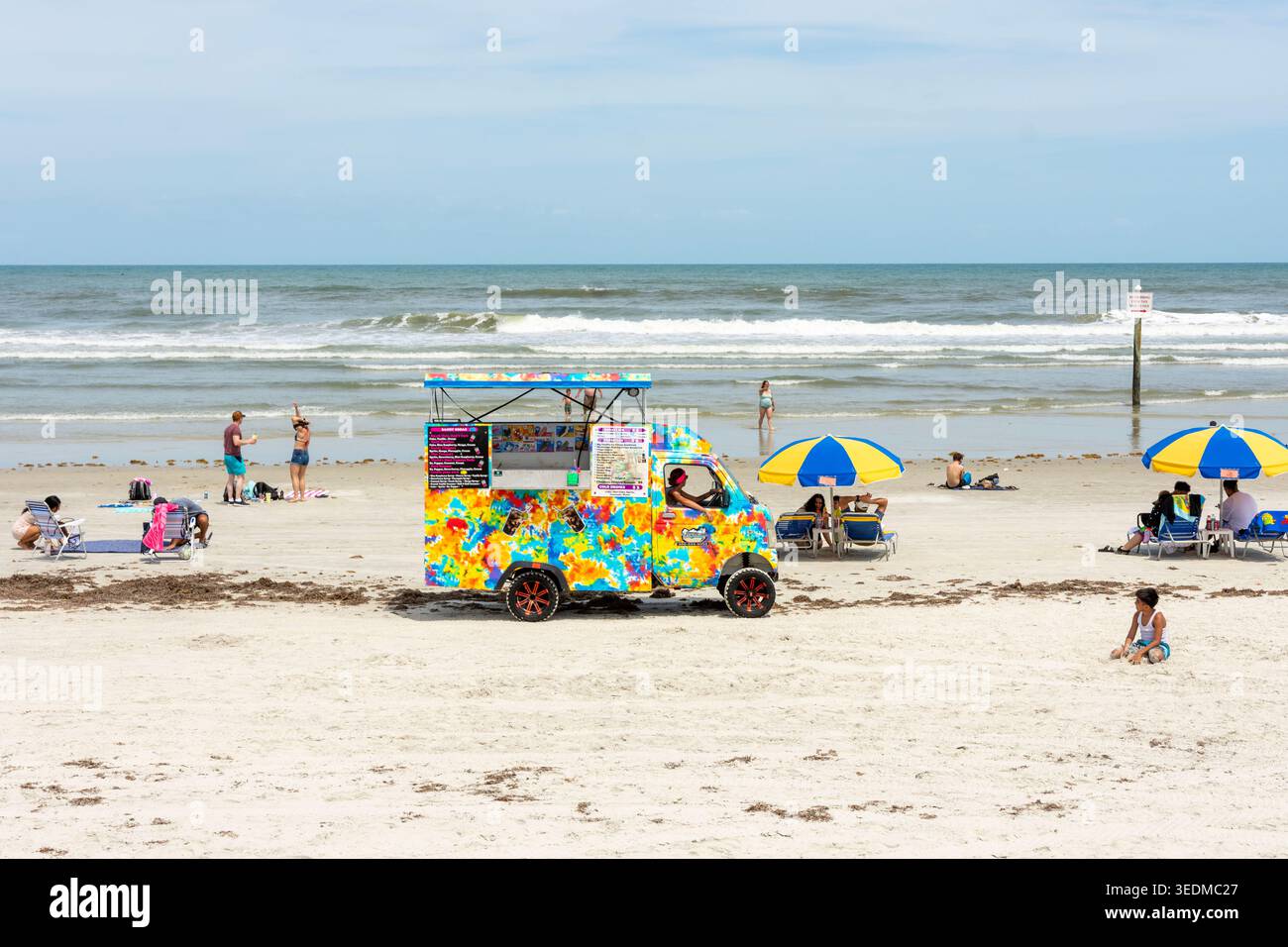 Ein farbenfroher Eiswagen, der auf dem Sand am Daytona Beach fährt. Stockfoto