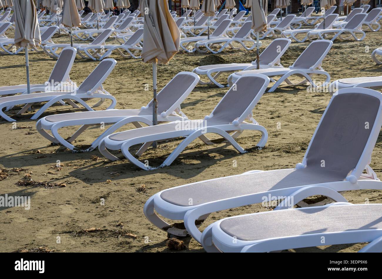 Leere Strandliegen mit Sonnenschirmen Stockfoto