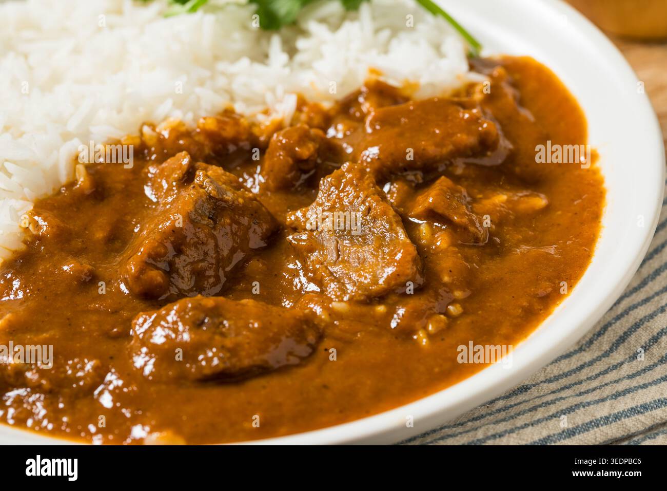 Hausgemachtes indisches Lamm Vindaloo mit Reis und Koriander Stockfoto