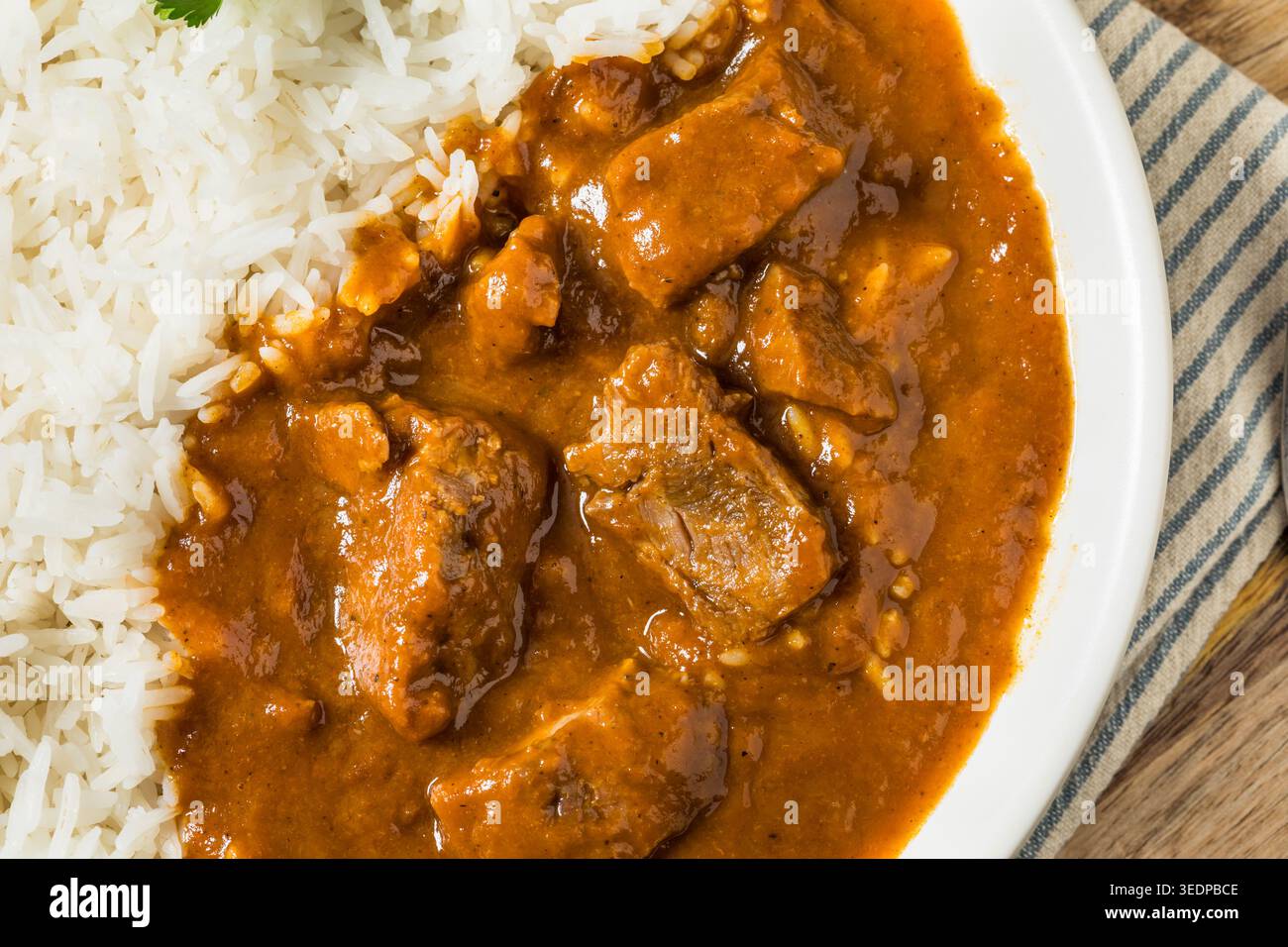 Hausgemachtes indisches Lamm Vindaloo mit Reis und Koriander Stockfoto