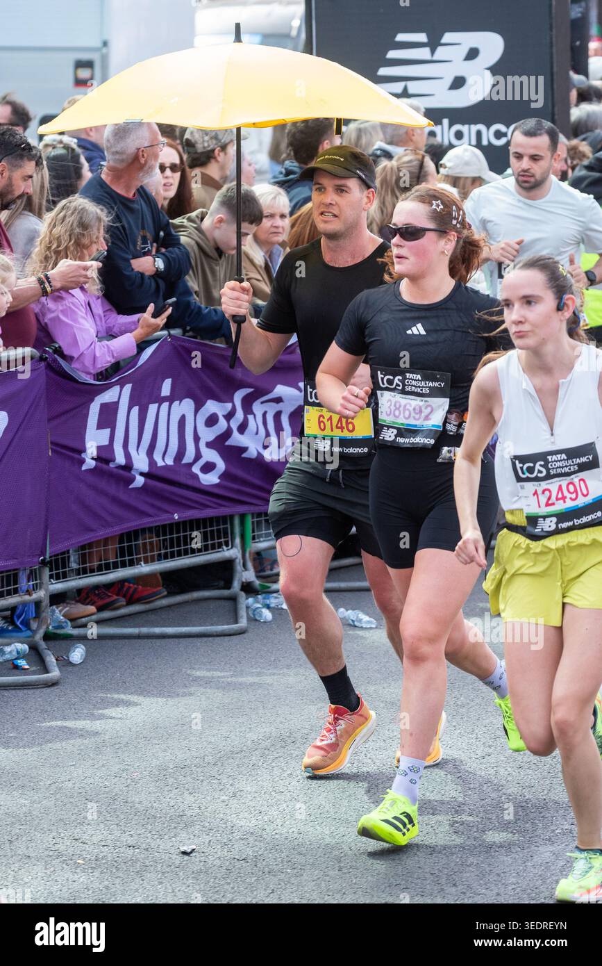 Taylor Manning lief mit einem Schirm am TCS London Marathon 2026 in London, Großbritannien. Stockfoto