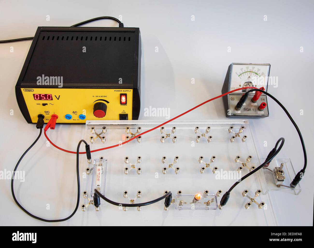 Pädagogische Physik mit Reihenschaltung. Das Set enthält ein einstellbares Netzteil (derzeit auf 5,0 V DC eingestellt), ein analoges Amperemeter, Kabel, A Stockfoto