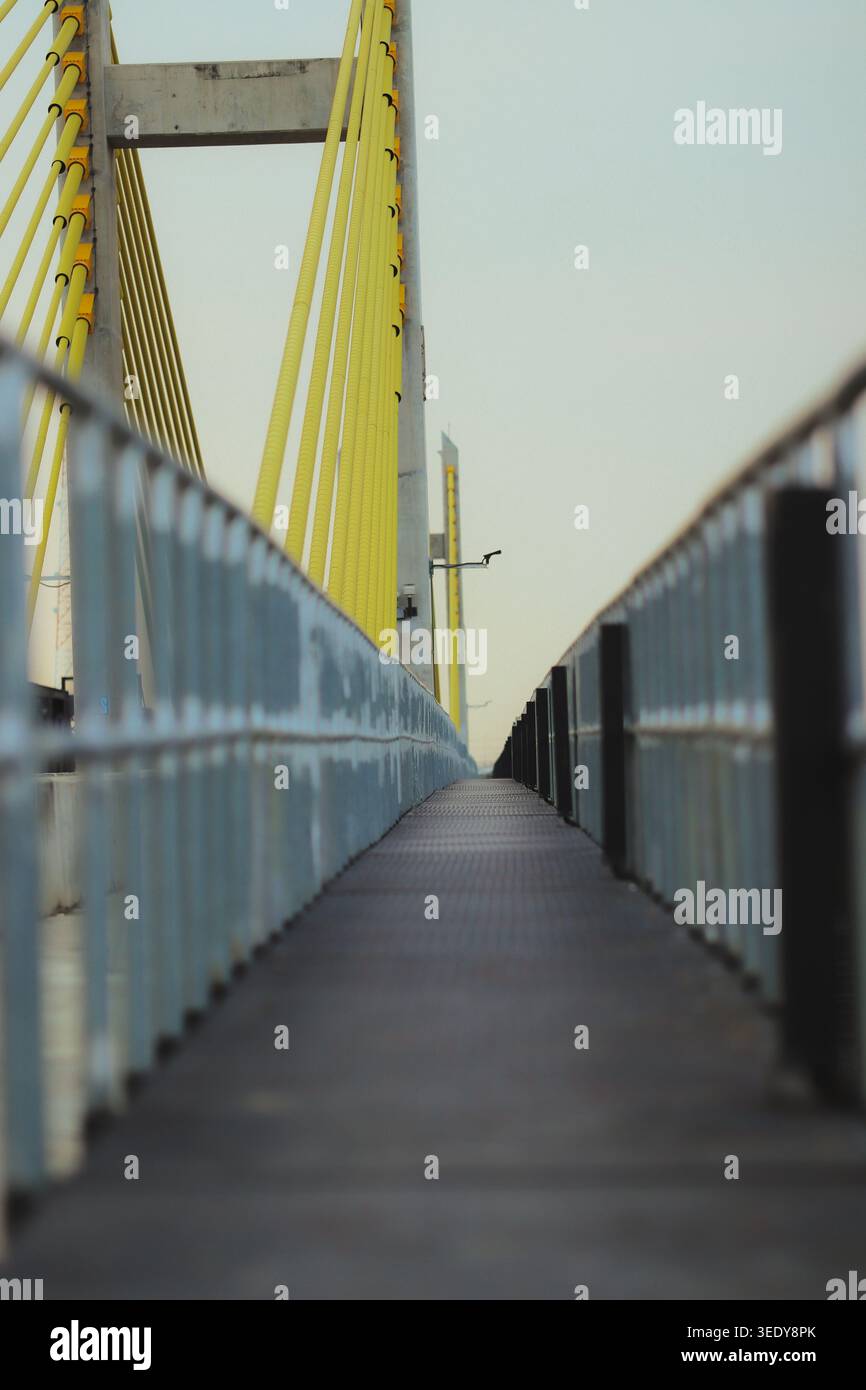 Tiefperspektivische Sicht auf einen modernen Hängebrücken-Fußweg in Thailand. Leerer Pfad, der die Atmosphäre des Grenzraumes und die Kunst der urbanen Ingenieurskunst repräsentiert. Stockfoto