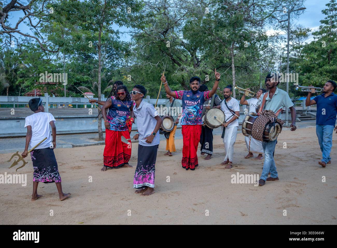 Hinduistische Pilger tanzen und spielen Musikinstrumente, während sie entlang der Kirivehera Road in der heiligen Stadt Kataragama in Sri Lanka paraden Stockfoto