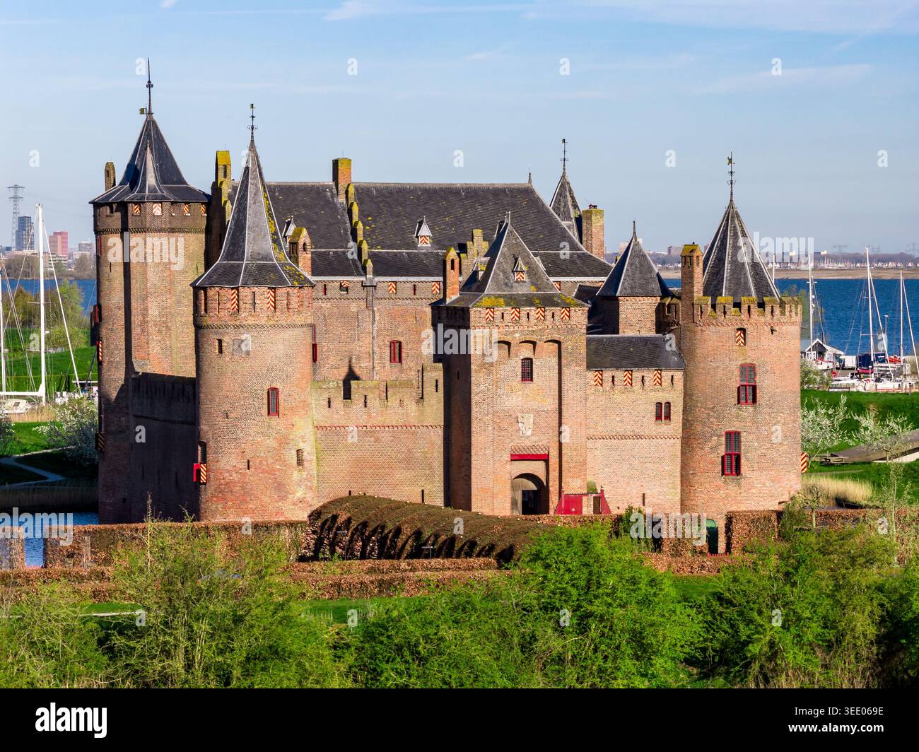 Nahaufnahme von Muiderslot, der mittelalterlichen Burg von Muiden, mit den reichen roten Ziegelmauern und den schiefergedeckten Ecktürmen mit Zinnen und Zinnen Stockfoto