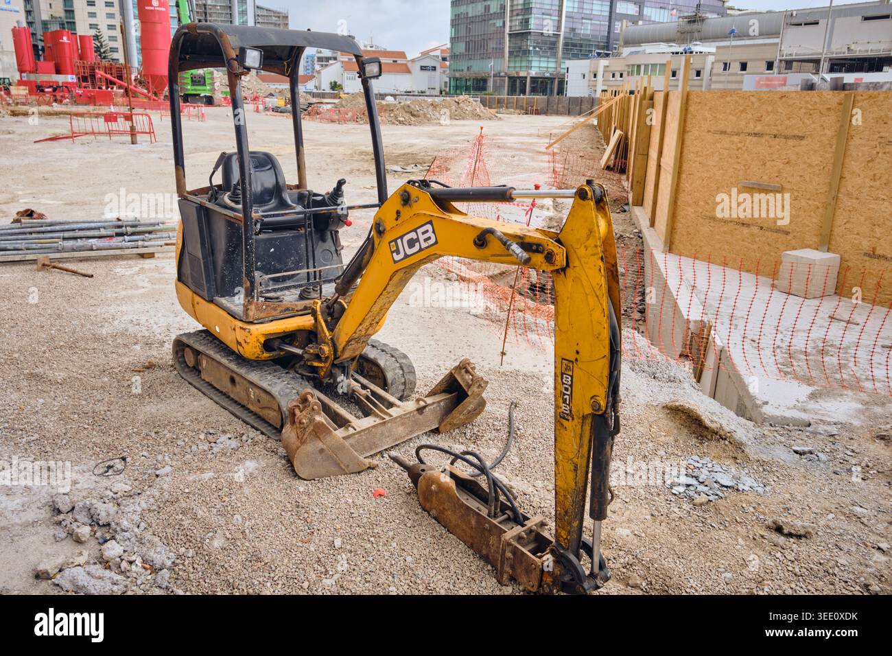 Baustellenabbruch mit gelbem Minibagger und Hydraulikhammer an Einem bewölkten Tag in der Altstadt von Gibraltar Stockfoto