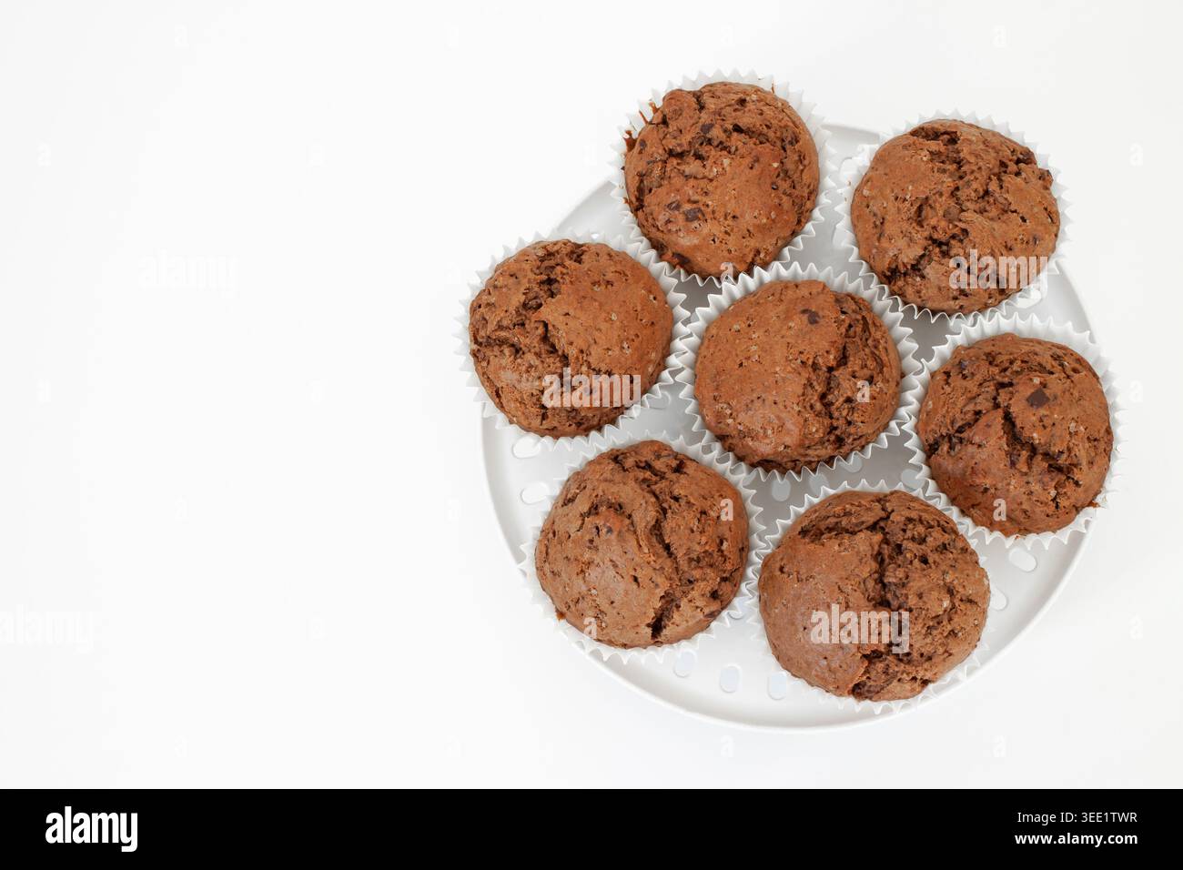 Gruppe von Schokoladenmuffins auf weißem Kunststoffständer isoliert auf weißem Hintergrund mit Kopierraum Stockfoto