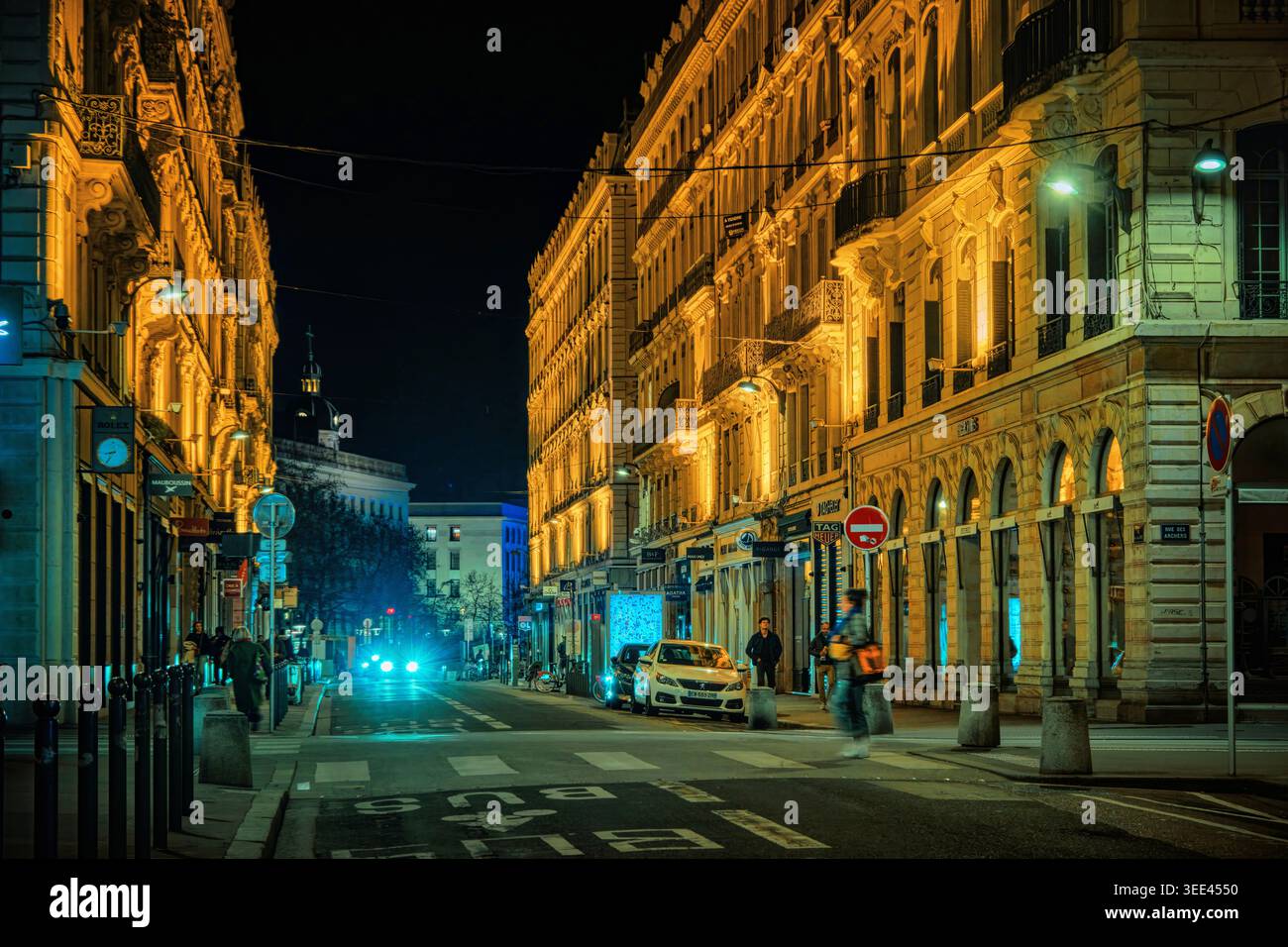 Lyon, Frankreich - 19. März 2026: Nächtlicher Blick auf eine historische Stadtstraße mit beleuchteten klassischen Gebäuden und warmen goldenen Lichtern im Stadtzentrum. Stockfoto