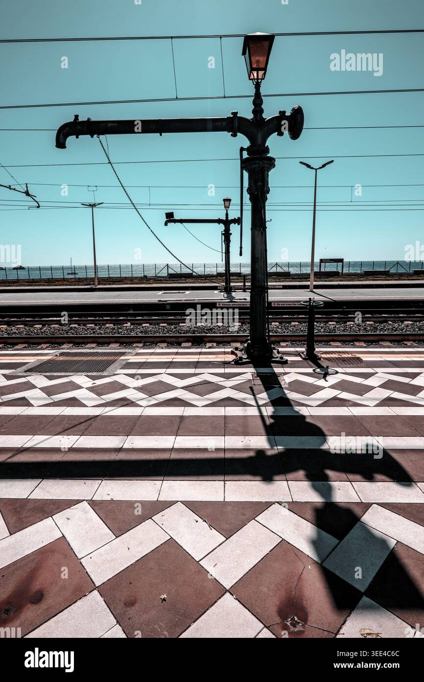 Ein Blick von einem Bahnsteig in Giardini Naxos, Sizilien, mit einem Lampenpfosten im Vintage-Stil und komplizierten Drähten. Der Vordergrund wird angezeigt Stockfoto