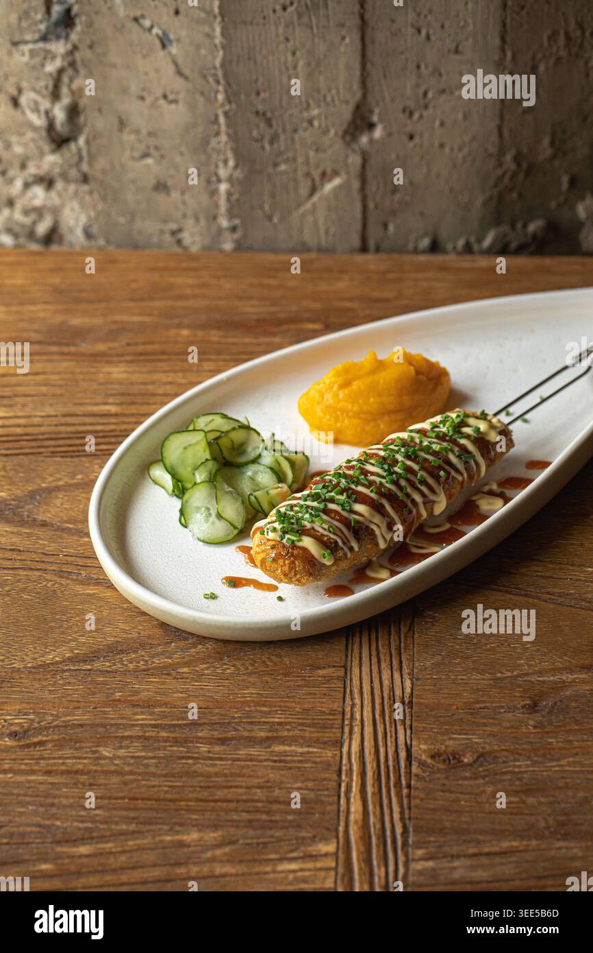 Knusprige Maishunde mit Soße und Kräutern auf Teller Stockfoto